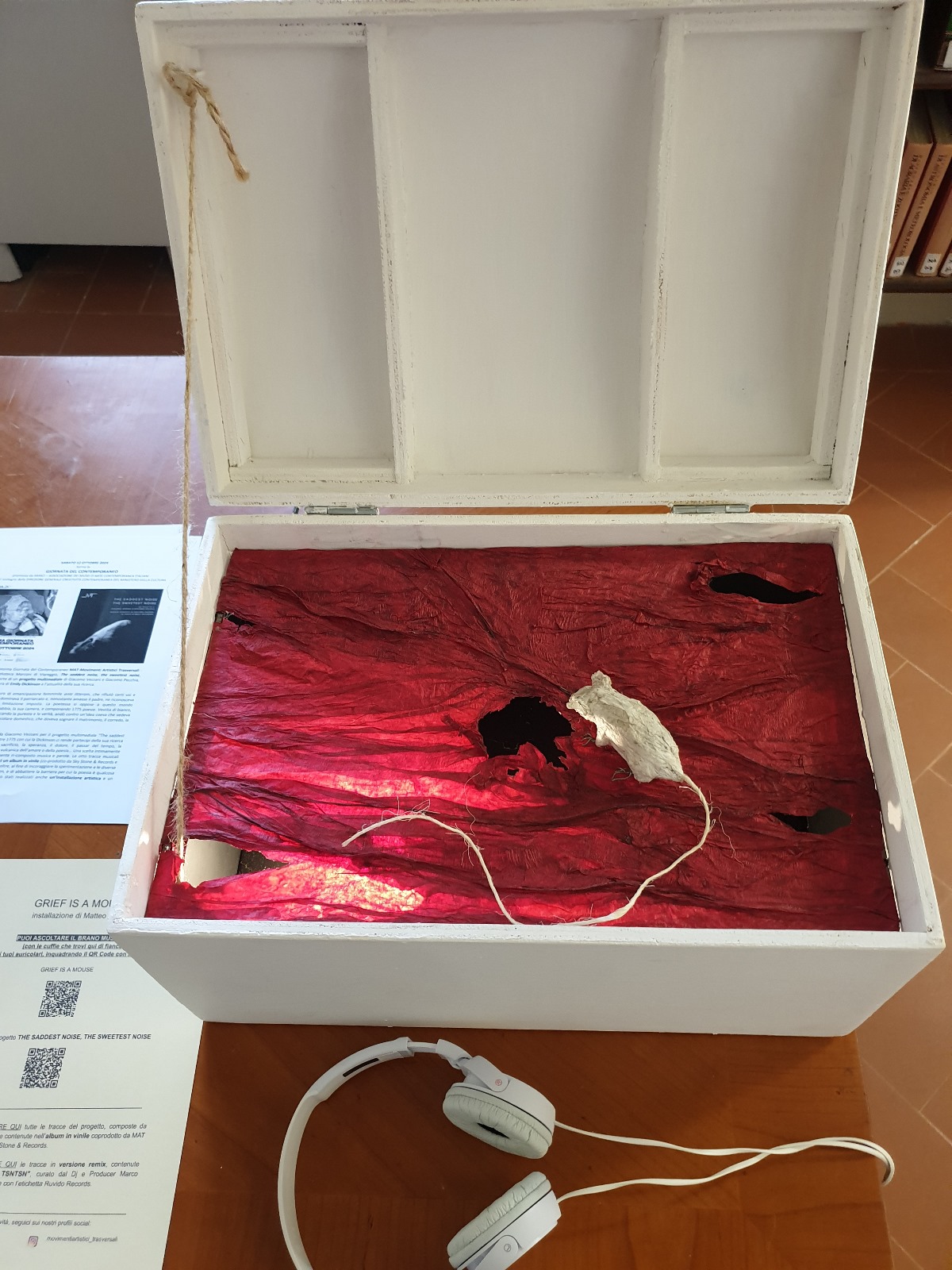 Immagine che mostra per intero lo scrigno Grief Is a Mouse, con scultura di un topo in cartapesta su una base rossa illuminata